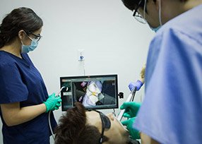 Dentist and dental assistant looking at intraoral photos