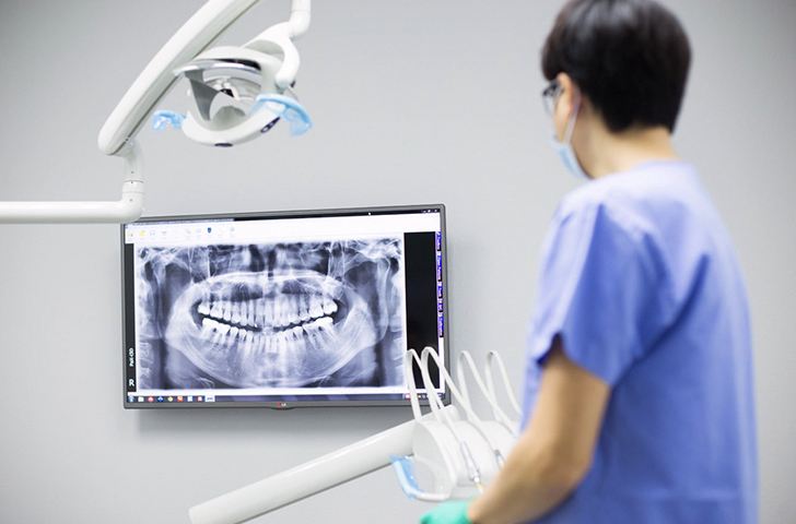 Dentist looking at digital x-rays