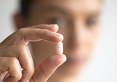 Hand holding antibiotic tablet pill